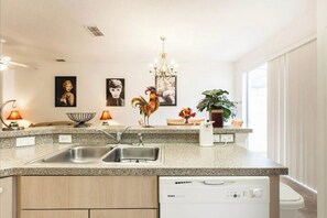 Enjoy cooking in this well-lit kitchen with a granite countertop, dishwasher, and stainless steel sinks.