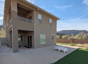 Un bâtiment à deux étages doté d’un balcon, d’une terrasse avec mobilier d’extérieur et offrant une vue sur les montagnes.