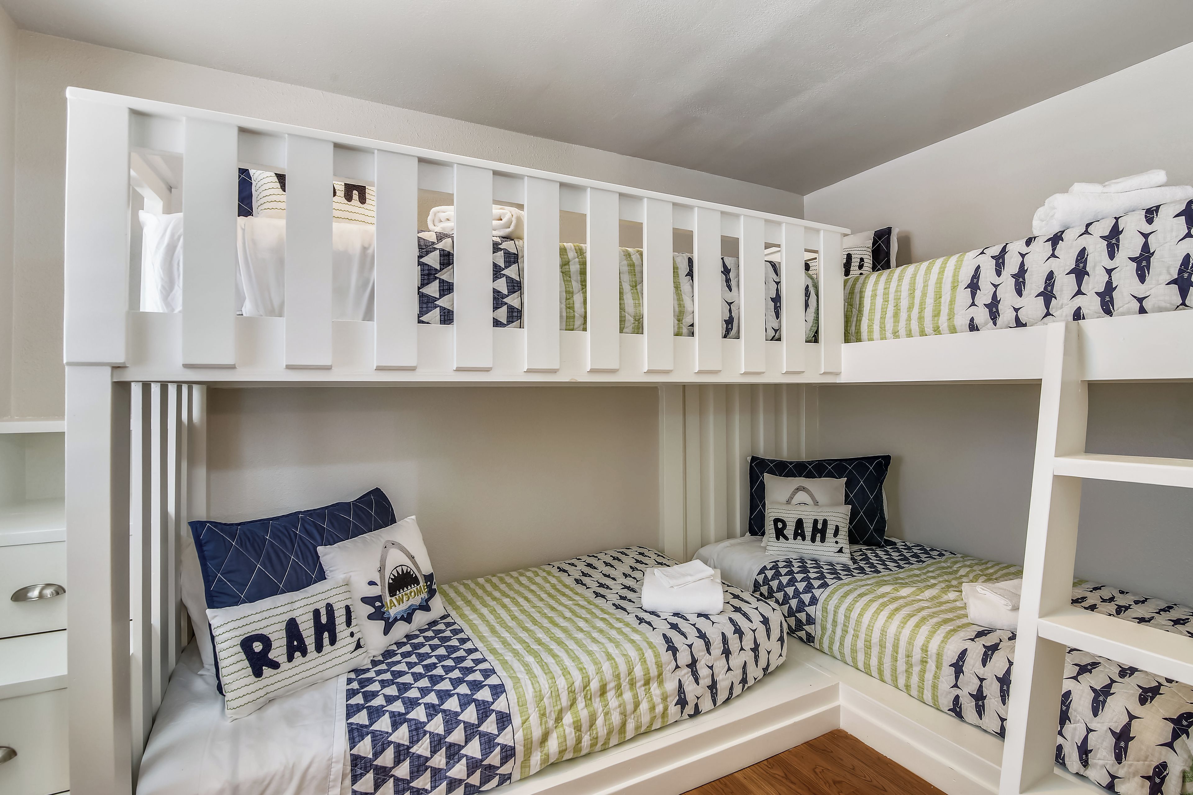Habitación con literas, dos camas, cada una con ropa de cama y almohadas estampadas.