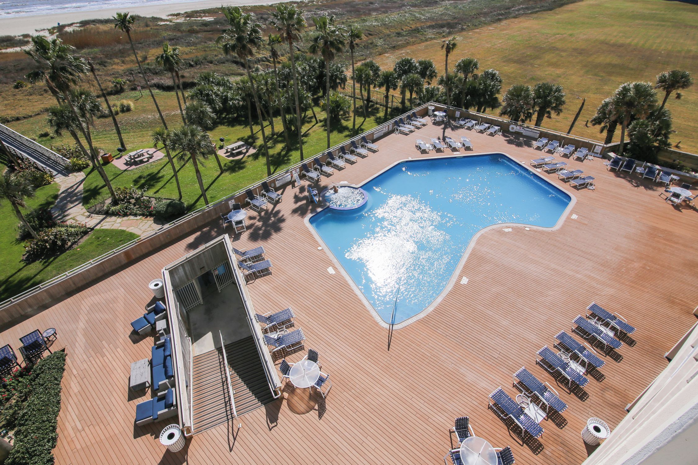 Zona de piscina con sillas de descanso y un jacuzzi en una terraza.