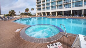 A hotel pool area with a hot tub, lounge chairs, and a sign indicating a 3 ft 6 in depth. - Pelican Pathway by Ryson Vacation Rentals (Galveston)