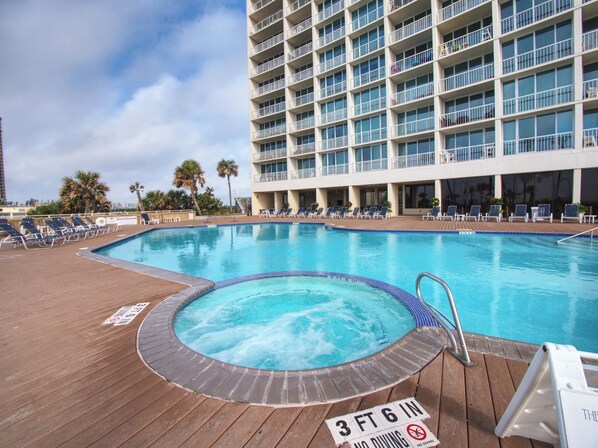 Área de piscina de hotel com hidromassagem, espreguiçadeiras e placa indicando profundidade de 1,07 metros.