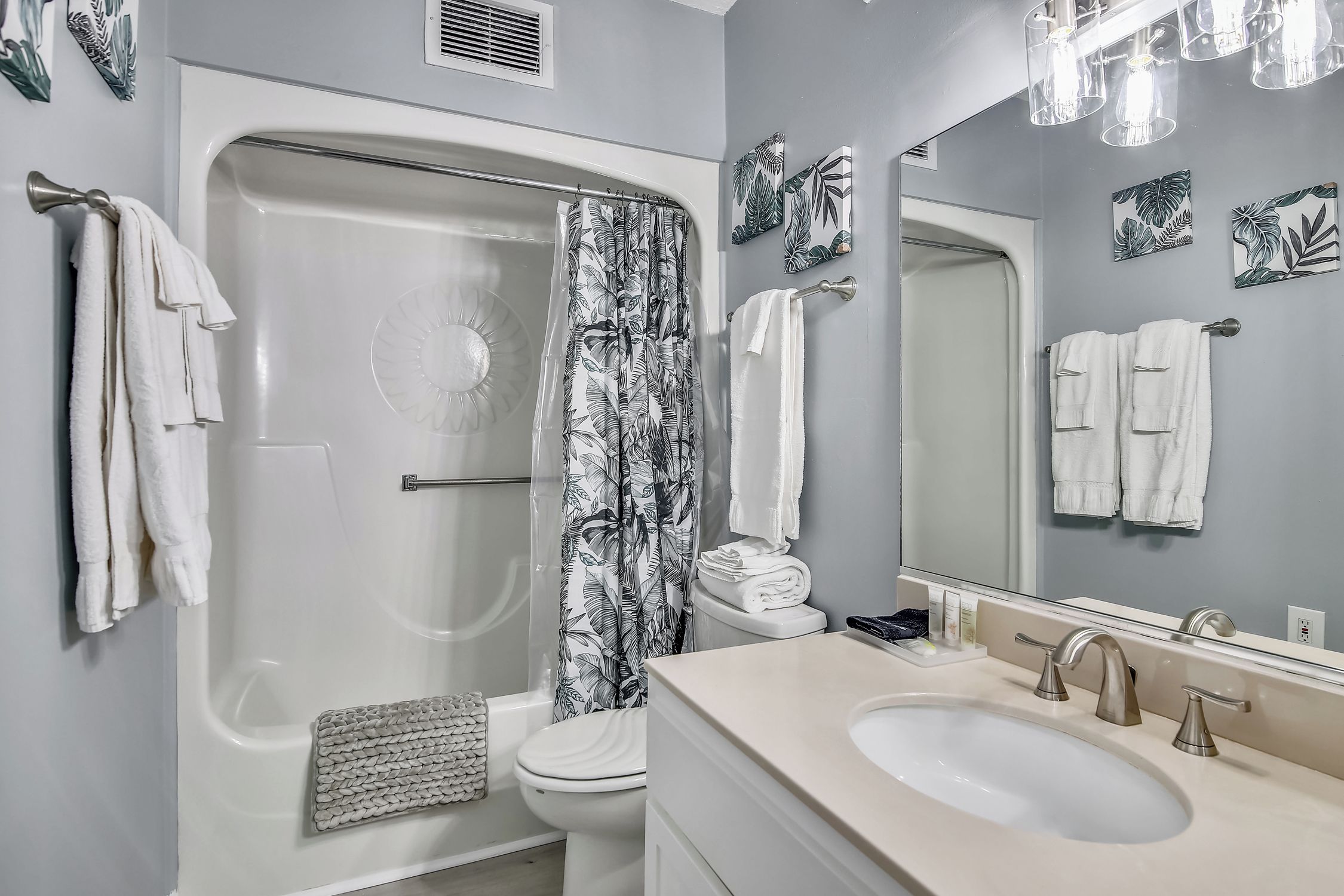 A bathroom with a bathtub, toilet, sink, and shower curtain.