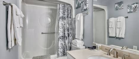 A bathroom with a bathtub, toilet, sink, and shower curtain.