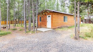 A wooden cabin with a gravel driveway, surrounded by tall pine trees. - Le Chalet at Mack's Inn CLOSE TO YELLOWSTONE 里黄石公园很近；我说中文！ (Island Park)