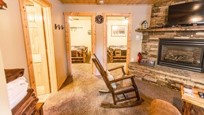 A cozy room with a fireplace, wooden walls, and a rocking chair. - Le Chalet at Mack's Inn CLOSE TO YELLOWSTONE 里黄石公园很近；我说中文！ (Island Park)