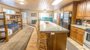 A kitchen with wooden cabinets, a granite countertop, and a stainless steel refrigerator. - Le Chalet at Mack's Inn CLOSE TO YELLOWSTONE 里黄石公园很近；我说中文！ (Island Park)