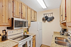 Enjoy cooking in this well-equipped kitchen with a stove, refrigerator, and microwave.