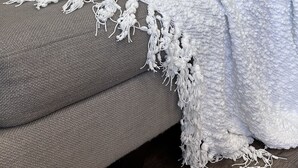 A grey sofa with a white and grey patterned throw blanket and pillows. - Cozy 2 bdrm Unit/Big Kitchen-2 TV- University City (Philadelphia)