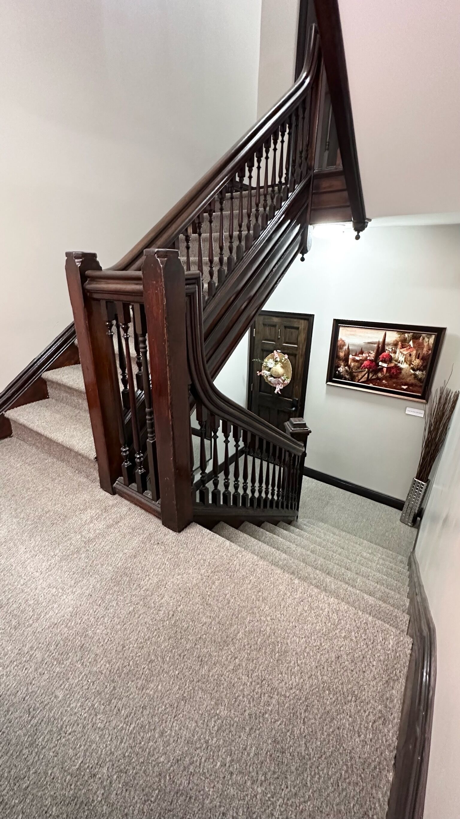 Una escalera de madera con acabado oscuro y barandilla decorativa.