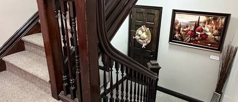 Una escalera de madera con acabado oscuro y barandilla decorativa.
