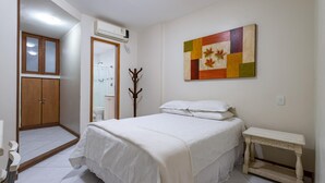 A bedroom with a bed, bedside table, and a painting on the wall. - 2 Minutes From Copacabana Beach A303 (Rio de Janeiro)