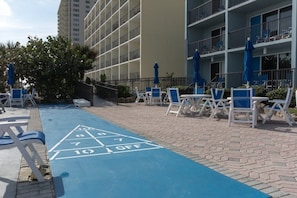 Relax in our courtyard, featuring a shuffleboard court and comfortable lounge seating.
