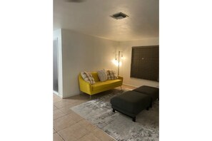 Relax in this stylish living room with a sofa, ottoman, and rug.
