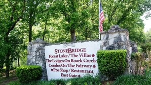 Schild für Stonebridge mit Annehmlichkeiten wie Forest Lake/The Villas, The Lodges am Roark Creek, Condos am Golfplatz, Pro Shop/Restaurant und East Gate.