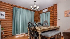 A dining area with a wooden table, chairs, and a bench. - Lakefront! Hot Tub-Fire Pit, game room, paddle boards & canoe! (Kimberling City)