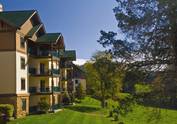 Experience the charm of this traditional hotel, featuring a central entrance and balconies on every floor, surrounded by lush lawns and mature trees.