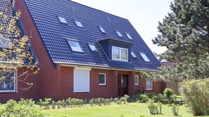 A two-story house with a sloped roof, skylights, and a brick exterior.