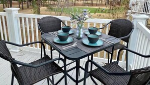 A dining table with chairs on a wooden deck, overlooking a golf course. - Calm Retreat or Golf Getaway! Close to Local  Attractions. (Calabash)