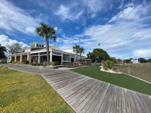 A building with a covered patio area, a wooden deck, and a grassy lawn. - Calm Retreat or Golf Getaway! Close to Local  Attractions. (Calabash)