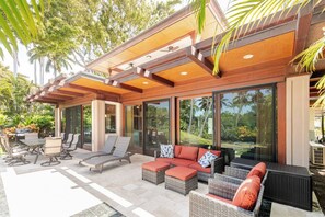 Eine Außenpatio mit Sitzgelegenheiten, einer Pergola und Blick auf die grüne Umgebung.