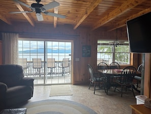 A cozy cabin interior with a dining area, a sofa, and a ceiling fan. - Ossipee Lake Water Front Property (Ossipee)