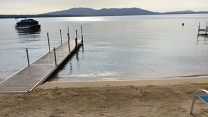 A wooden pier extending into calm water with a boat docked at the end.