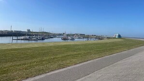 A marina with boats docked, a grassy area, and a clear sky. - Stunning  villa for 4 people with TV and terrace (Norden)