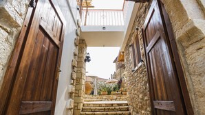 A narrow stone alleyway with wooden doors and a small set of stone steps leading to a balcony. - Albanian Coast - House - Stay 9 - Hottub - Petsok (Himarë)