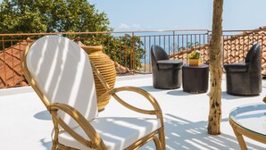 A terrace with wicker chairs, a glass table, and a potted plant. - Albanian Coast - House - Stay 9 - Hottub - Petsok (Himarë)