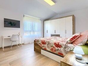 Cozy retreat with a bed, desk, and TV, perfect for relaxation and work.