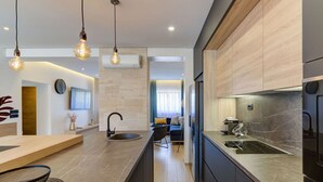 A modern kitchen with a central island, pendant lighting, and a view into the living area. - Stunning private villa with A/C, private pool, WIFI, hot tub, TV, terrace and pets allowed (Novi Vinodolski)