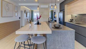 A modern kitchen with a central island, bar stools, pendant lighting, and a view into the living area. - Stunning private villa with A/C, private pool, WIFI, hot tub, TV, terrace and pets allowed (Novi Vinodolski)