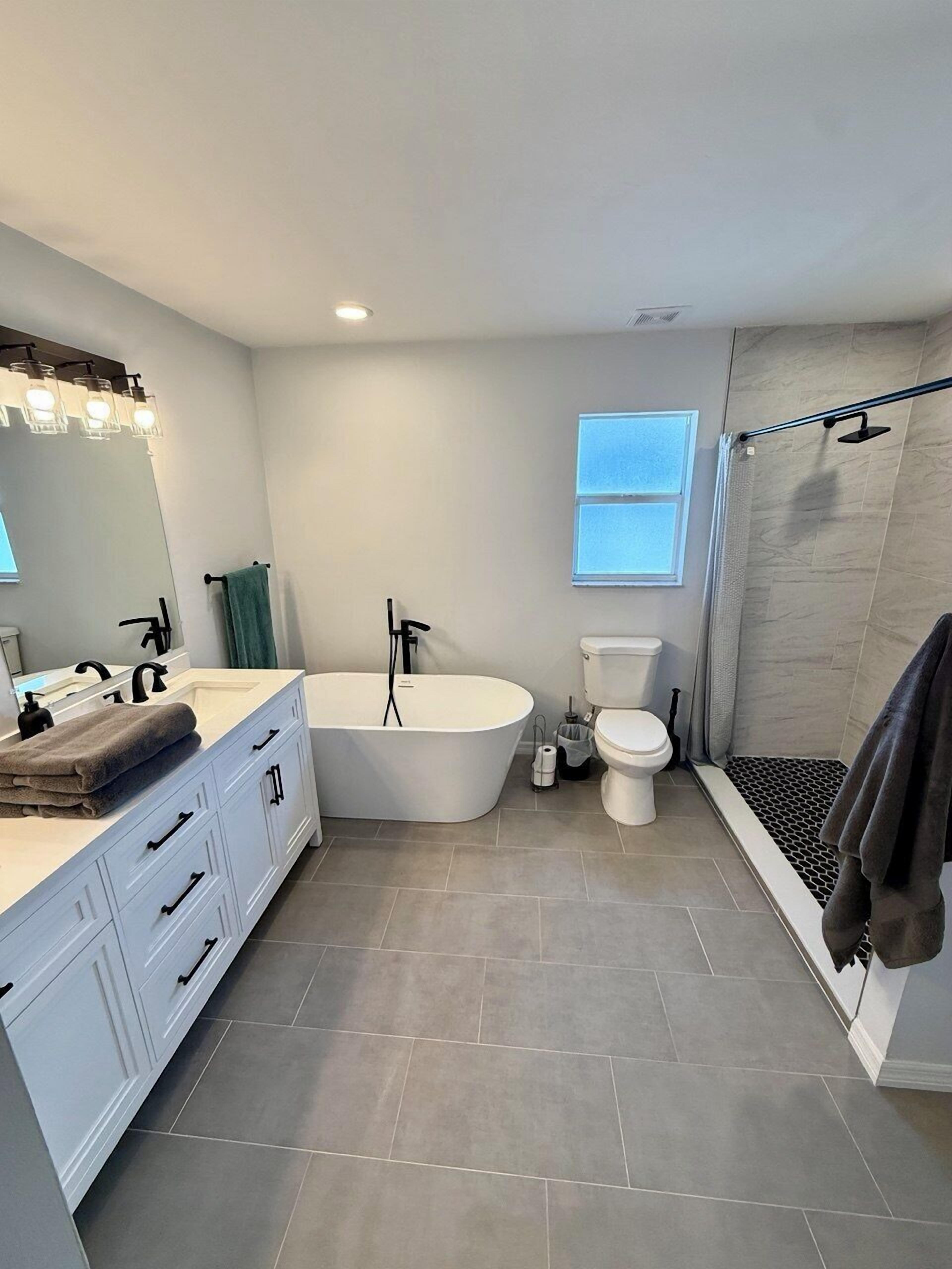 Une salle de bain moderne avec une baignoire sur pieds, des toilettes et un espace douche.