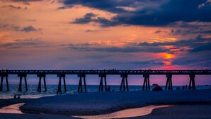 A pier extending into the water with people on it.