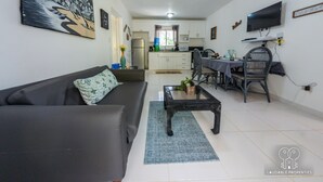 Una sala de estar con sofá, mesa de centro y comedor con sillas y mesa.