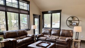 A living room with two brown leather sofas, a wooden coffee table, and a side table with a lamp. - Luxury 3 Bedroom Mountain Townhome in Keystone (Dillon)