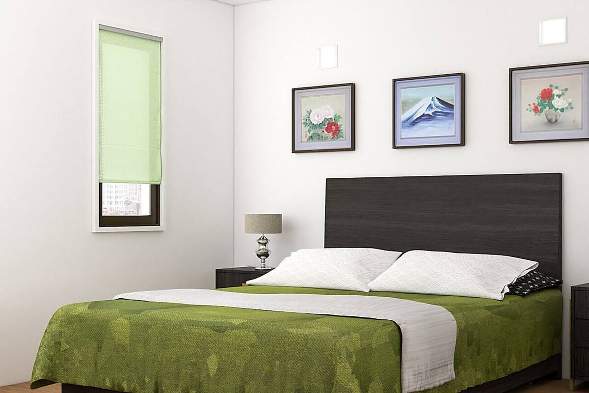 Un dormitorio ordenado con cama, mesitas de noche y cuadros en la pared.