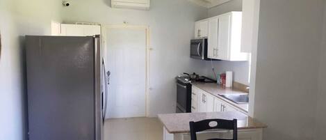 Frigorífico, microondas, placa de cocina y utensilios de cocina