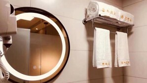 A bathroom with a round mirror, a towel rack with neatly folded towels, and a towel warmer. - Yunqi Hotel (Jiulong)