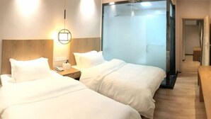 A hotel room with two beds, a wooden headboard, a nightstand, and a glass partition. - Yunqi Hotel (Jiulong)