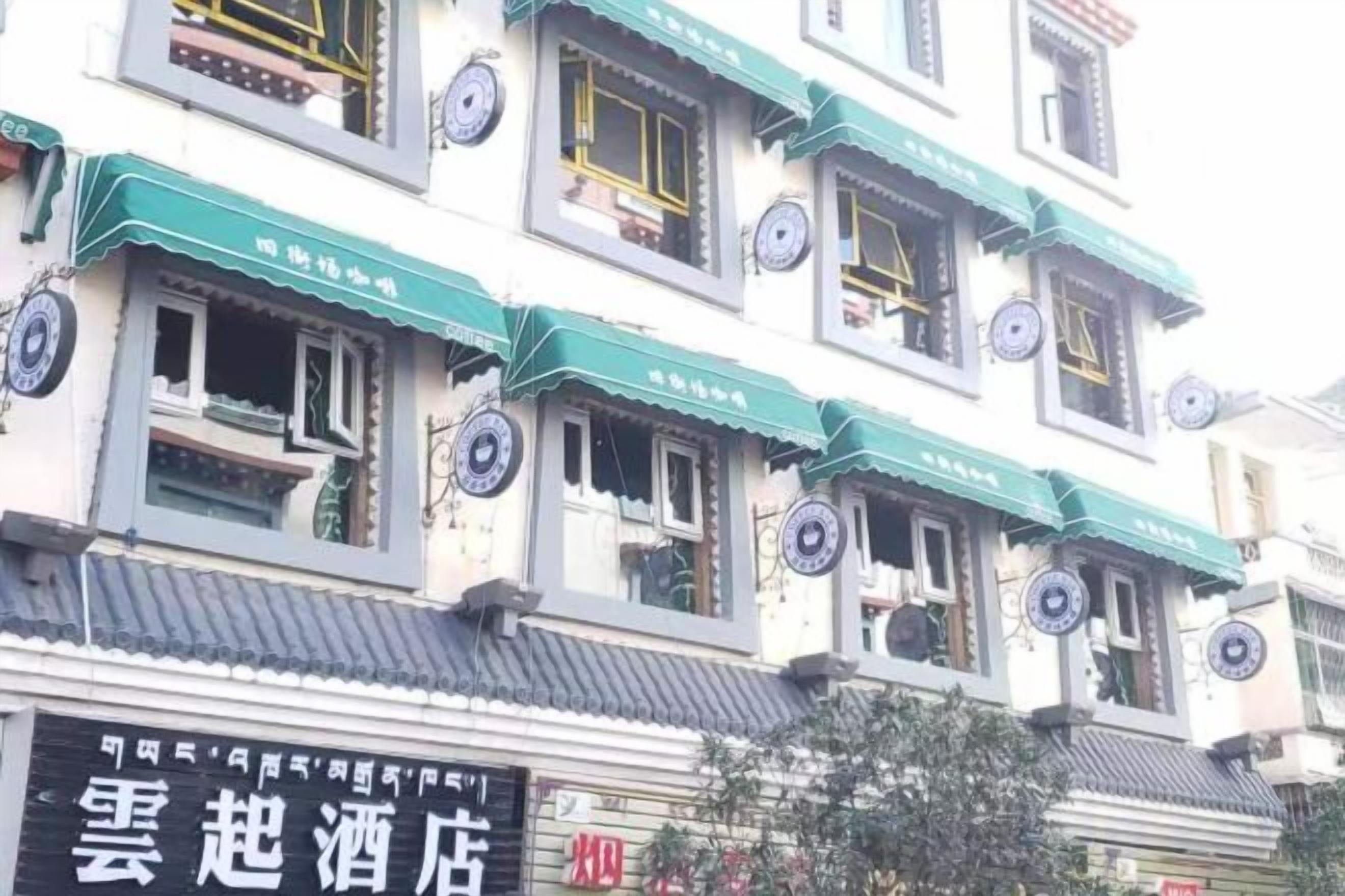 Een hotel met traditionele Chinese architectuur, herkenbaar aan groene luifels en ronde decoraties op de ramen.