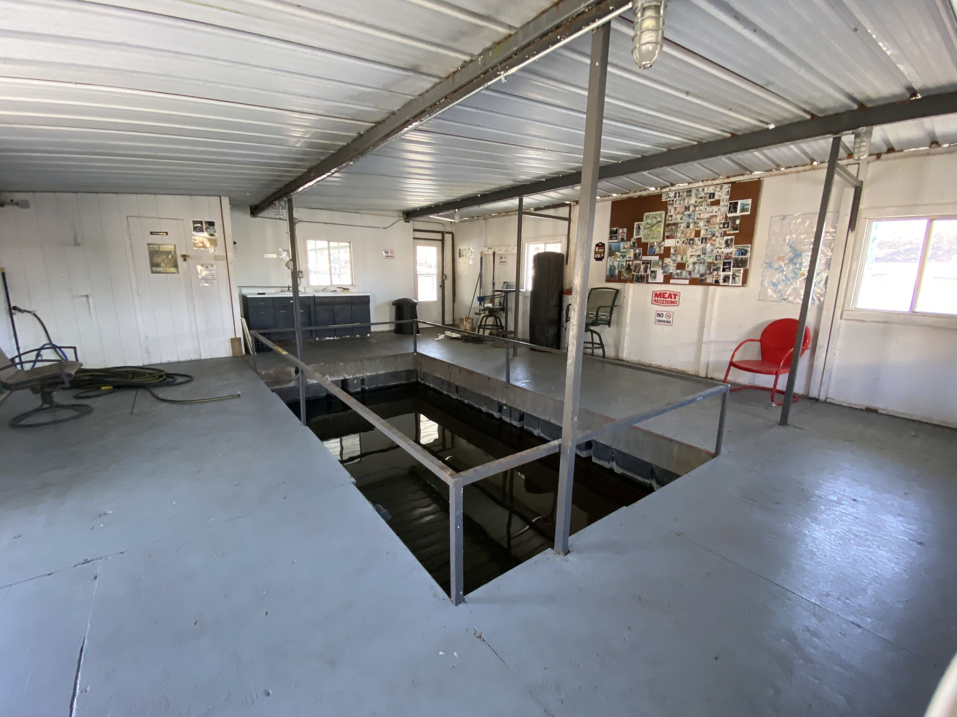 A large industrial space with a central water feature, metal beams, and a red chair.