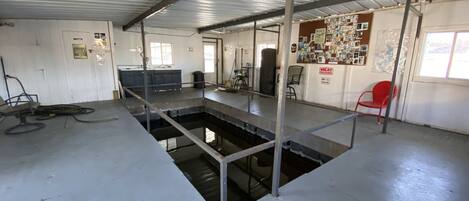 A large industrial space with a central water feature, metal beams, and a red chair.