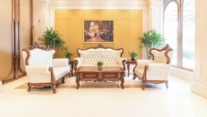 A formal sitting area with a tufted sofa set, two armchairs, and a wooden coffee table. - Vienna International Hotel (Jinan Shandong International Convention and Exhibition Center) (Jinan)