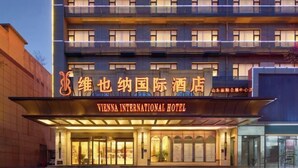 The Vienna International Hotel facade with illuminated signage, multiple balconies, and a modern architectural design. - Vienna International Hotel (Jinan Shandong International Convention and Exhibition Center) (Jinan)