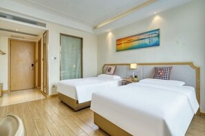 A hotel room with two beds, a painting on the wall, and a wooden door. - Vienna 3 Best Hotel (Foshan Jinsha Central Square) (Foshan)