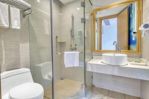 A modern bathroom with a glass-enclosed shower, a white toilet, and a vanity with a large mirror. - Vienna 3 Best Hotel (Foshan Jinsha Central Square) (Foshan)