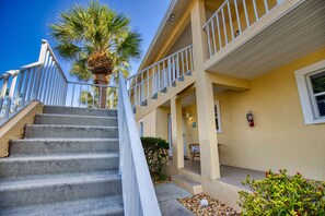 A hotel with a concrete staircase leading to a balcony, a palm tree, and a fire extinguisher on the wall. - TwoMorrows Treasure: Beaches,Pickleball on Property,Boating,Biking, Golf, Nature (Englewood)