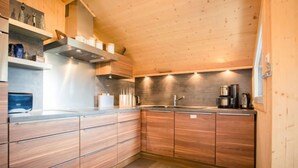 Une cuisine moderne avec des meubles en bois, une hotte en acier inoxydable et un évier encastré.